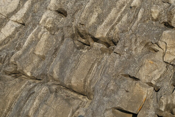 The abstract shapes, patterns and textures of the limestone surface appear to be layered.Natural pattern and texture background. Copy space.Limestone wall on the edge of the lake. For graphic design 