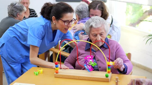 Senior woman and caregiver playing skill board games in the nursing home