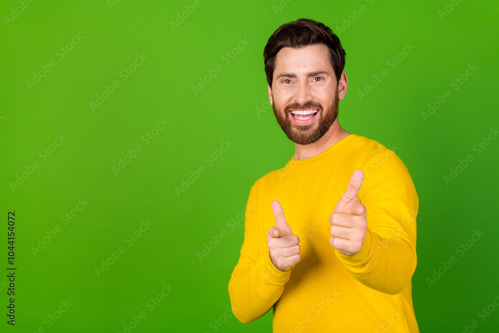 Poster photo of cool handsome man with stylish beard dressed yellow shirt directing at you near empty space