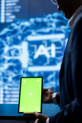 Technician in startup doing advancements in AI field using chroma key tablet. Close up of green...