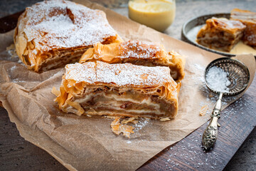 Traditional Bavarian apfelstrudel with backed apples, raisins and icing sugar served as close-up on...
