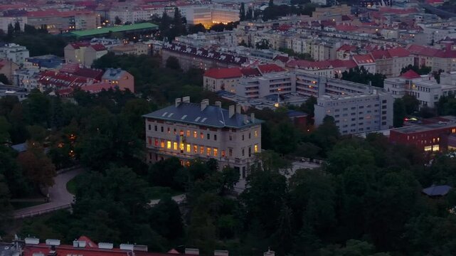 Aerial views capture Grobe Villa in Praha 2 Vinohrady neighborhood at night, showcasing glowing buildings and creating an enchanting ambiance in the lively cityscape