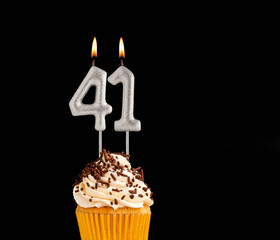 Number 41 shaped candles - Birthday cupcake on black background.