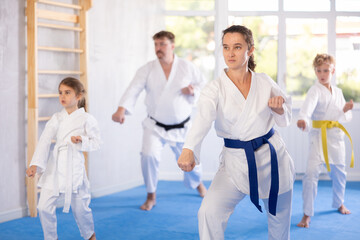 Family with two children in kimono trains karate techniques in studio © JackF