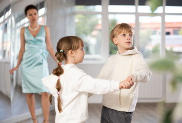 Boy with pair girl in sport wear train to dance vigorous hustle during classes. Children rehearse...