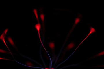 A glowing plasma ball with red and blue electric arcs radiating from its core against a dark background, creating a vivid and energetic display.