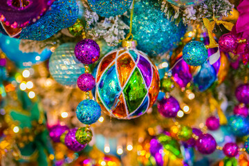 Christmas Wallpaper. Multicolored glass Christmas tree balls in gold, violet and blue tones.Shiny sparkling bright background. Colorful New Year and Christmas decorations background.Symbols of winter