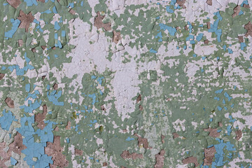 Peeling paint on the wall. Old concrete wall with cracked flaking paint. Weathered rough painted surface with patterns of cracks and peeling. Grunge texture for background and design. High resolution.