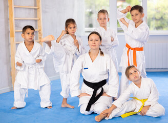With their instructor, children karate enthusiasts gather for group picture.
