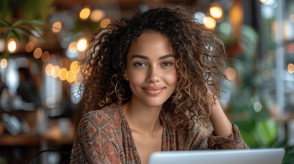 Young woman happily working on laptop in cozy urban cafe