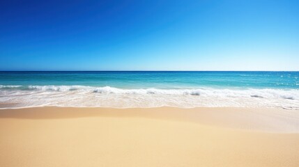Fototapeta premium Tranquil sandy beach with turquoise water and blue sky on a sunny day.
