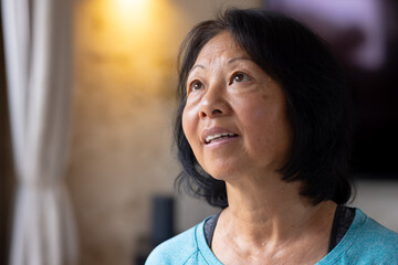 At home, Asian senior woman looking hopeful during Christmas season, festive atmosphere, copy space