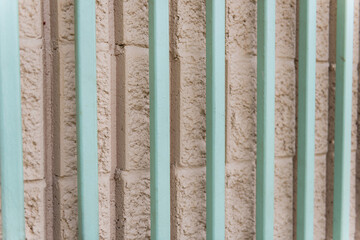 Turqoise metal bars in front of stone wall