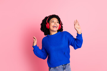 Photo portrait of curly brunette hair youngster woman enjoying red wireless headphones dancing isolated on pink color background