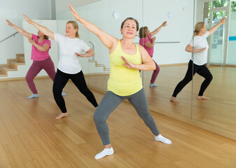 Fototapeta premium Elderly women having dance training in studio, practicing active dances, healthy lifestyle