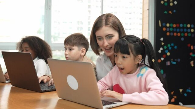 Smart teacher teaching and looking student using laptop at classroom. Professional instructor explained about programing engineering code or prompt while studying and learning program. Erudition.