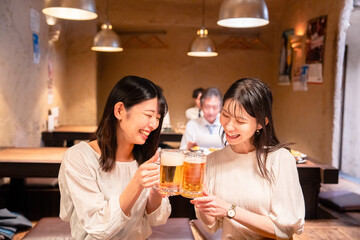 居酒屋で女子会をする二人の女性