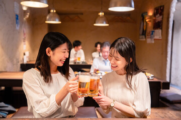 居酒屋で女子会をする二人の女性