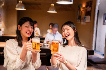 居酒屋で女子会をする二人の女性