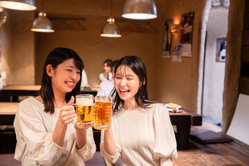 居酒屋で女子会をする二人の女性