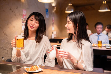 居酒屋で女子会をする二人の女性