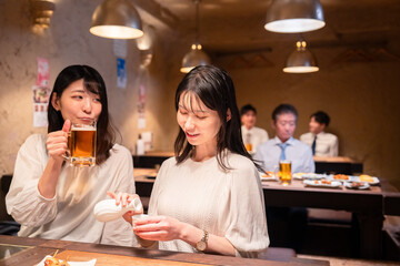 居酒屋で女子会をする二人の女性