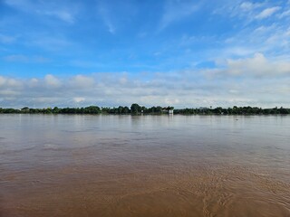 Calm River Landscape with Blue Sky and Fluffy Clouds