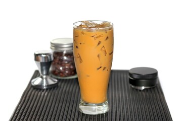 Ice Espresso Coffee serving on white background with coffee beans spread around glass.