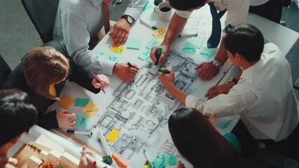 Group of diverse team planning strategy while sitting at table with project plan. Top aerial view of smart business people working together to brainstorm and design house construction. Alimentation.