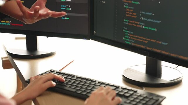 Slow motion back end or software developer manager supervising his team on new application program development on debugging and solving complex code algorithms on monitor. Burgeoning