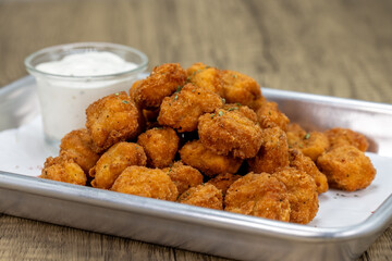 Crispy order of popcorn chicken nuggets on a tray with ranch dipping sauce