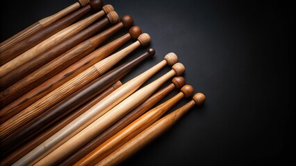 Cascading array of wooden drumsticks in various shades of brown on black background , drumsticks, wooden