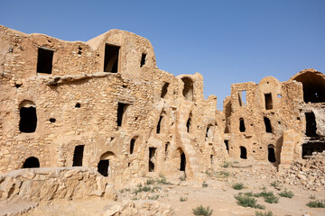 View of old Ksar Mgabla architecture with ruined storage areas in Tunisia
