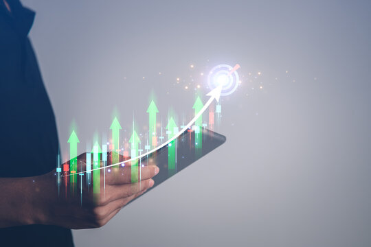 Business using mobile phont with exponential arrow and financial graph for business investment growth. Financial, data analysis, goal,success and money concept.