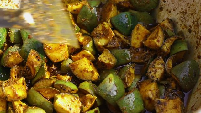 Making of Indian  Spicy Mango Pickle with Condiments Like Chilli Powder, Cumin Seed, Fenugreek, Fennel and Oil