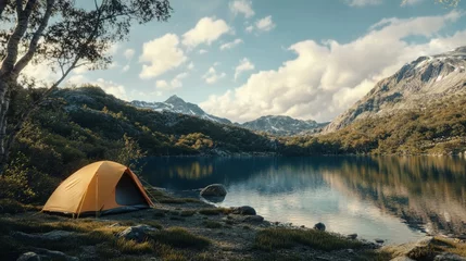 Fotobehang A tranquil lakeside camping scene featuring a tent surrounded by mountains and clouds, perfect for nature lovers. © Oulaphone
