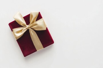 A red gift box wrapped with a ribbon, perfect for celebrations like Christmas, birthdays, or anniversaries, featuring a fe