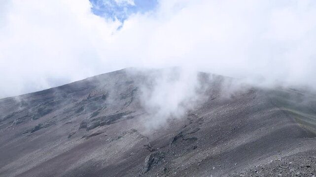 Clouds are rapidly moving across the sky above the Hoei Crater on Mt.Fuji, and focus moves to bottom. 4k 10bit footage