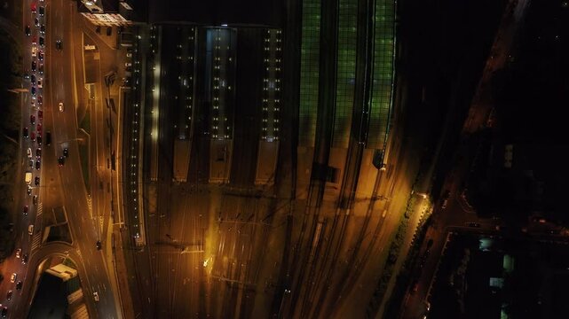 Bird's eye view of Prague's main railway station at night. Cars are driving on the adjacent roads and platforms are illuminated