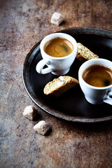 Cantuccini (Italian cookie) and Two Cups Of Coffee on rustic stone background. Copy space.
