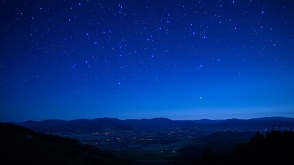 A serene night sky filled with stars over a tranquil landscape and distant lights.