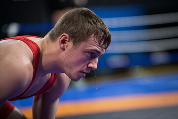 Fototapeta premium Close-up of a focused wrestler in a crouched stance, ready to grapple