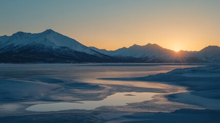 Serene mountain landscape at sunset, reflecting on the icy water below.