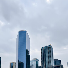 Fototapeta premium Modern buildings in city against cloudy sky