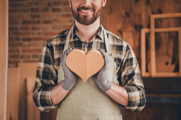 Cropped photo of professional cool master dressed uniform apron holding small wooden heart indoors house diy studio room
