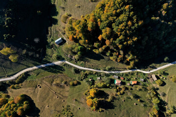 Aerial view of rural dirt village road in autumn