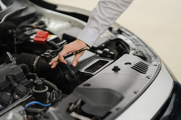Mechanic Inspecting Engine: A close-up shot of a mechanic's hand meticulously inspecting the engine...