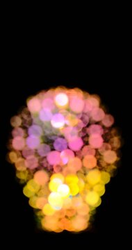 the silhouette of a decorative festive light bulb made of defocused colored circles 