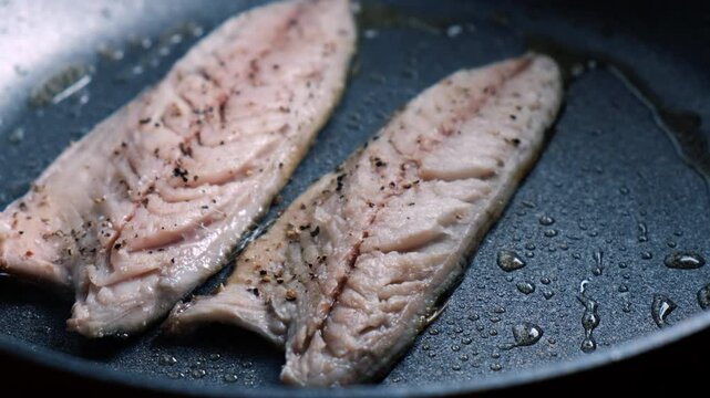 Cooking mackerel fish in a frying pan. A cook fries capelin in a restaurant kitchen before dinner. 