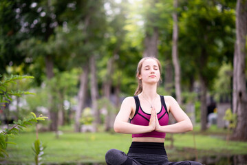 fit young women practicing yoga at park in the morning